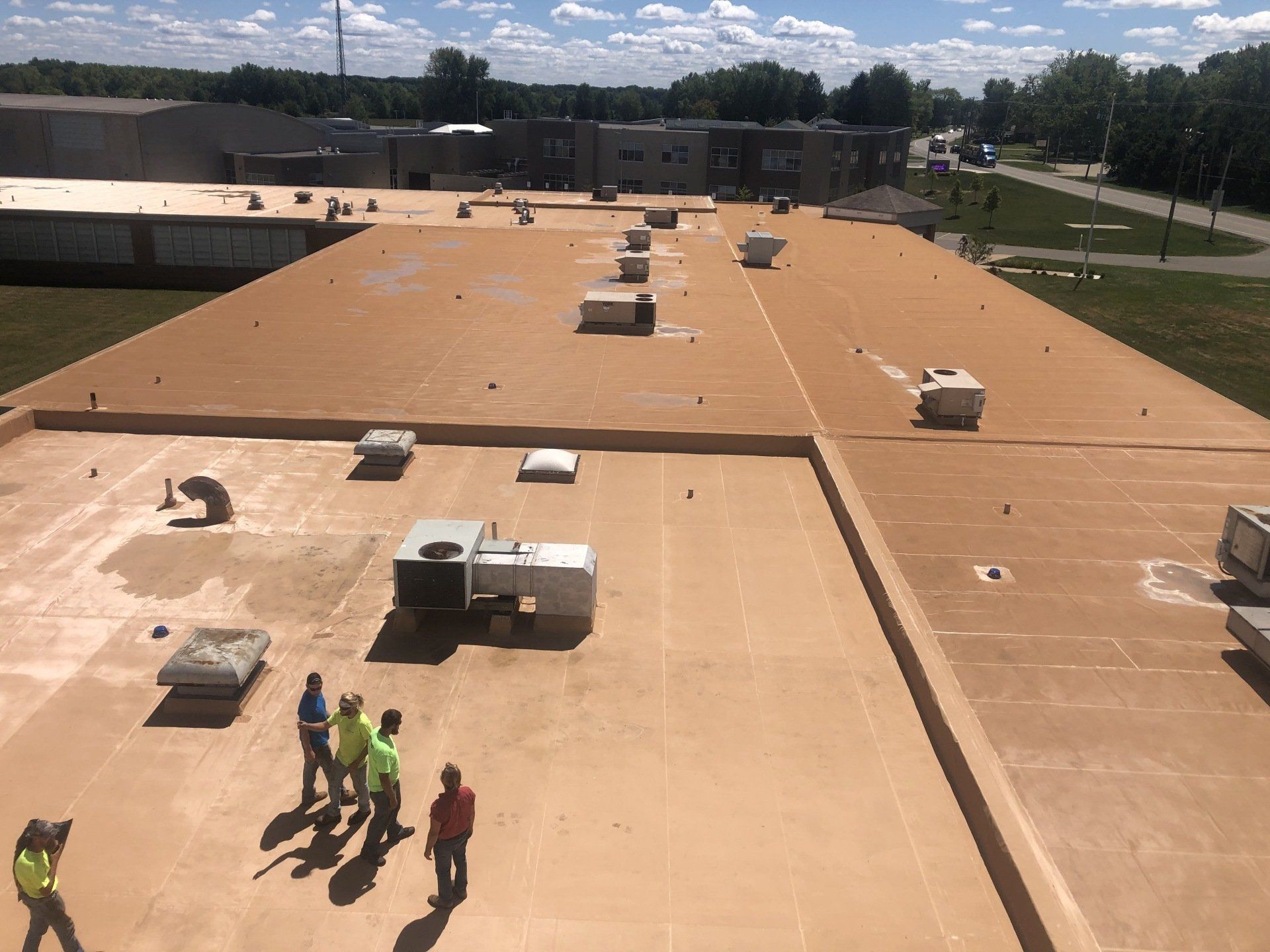 crew on top of completed commercial roof